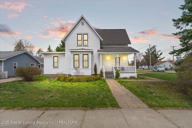 607 Ogemaw St, Grayling, MI 49738 - view of front of home featuring covered porch, a lawn, and a shingled roof
