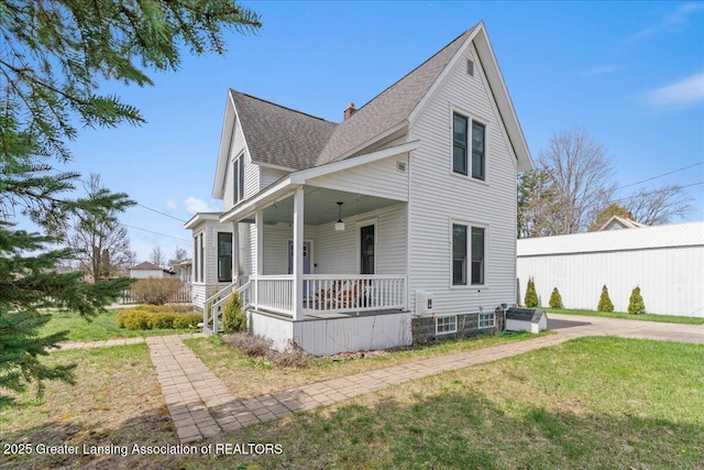 607 Ogemaw St, Grayling, MI 49738 - view of front of home featuring covered porch, a shingled roof, a front yard, and a chimney