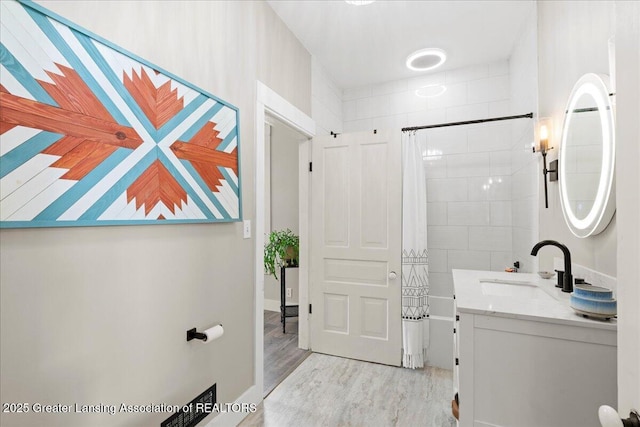 607 Ogemaw St, Grayling, MI 49738 - bathroom featuring shower / tub combo with curtain, vanity, and wood finished floors