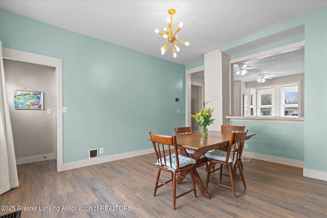 607 Ogemaw St, Grayling, MI 49738 - dining area featuring a chandelier, wood finished floors, and baseboards