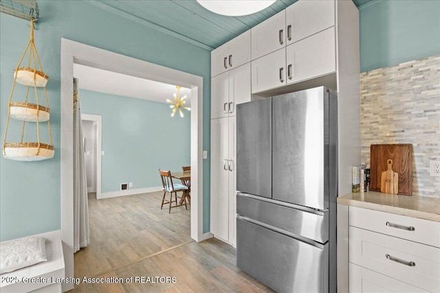 607 Ogemaw St, Grayling, MI 49738 - kitchen featuring freestanding refrigerator, white cabinets, light wood-style floors, a chandelier, and light countertops