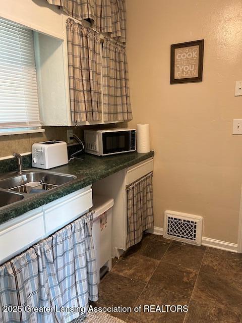 1209 Hapeman St, Lansing, MI 48915 - kitchen with baseboards and dark countertops