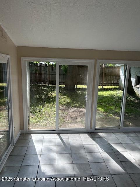 1209 Hapeman St, Lansing, MI 48915 - entryway featuring healthy amount of natural light, tile patterned floors, a textured ceiling, and lofted ceiling
