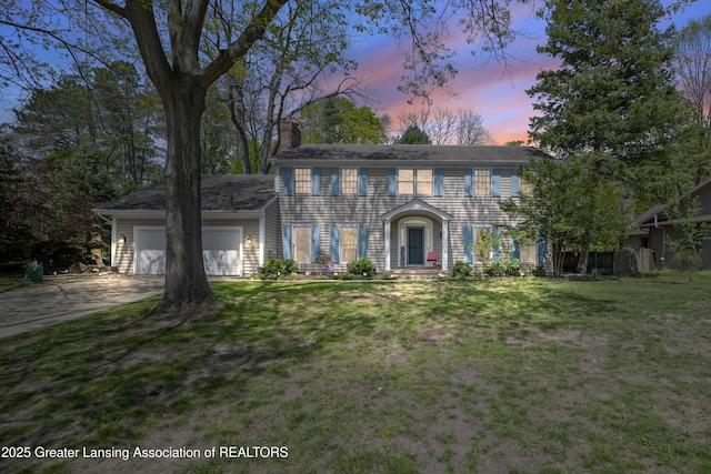 2038 Woodfield Rd, Okemos, MI 48864 - colonial house with a chimney, a garage, driveway, and a yard