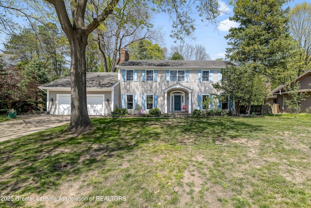 2038 Woodfield Rd, Okemos, MI 48864 - colonial home with a garage, a chimney, driveway, and a front yard
