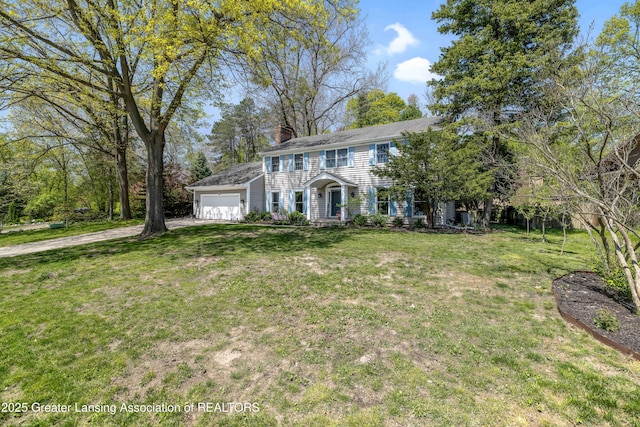 2038 Woodfield Rd, Okemos, MI 48864 - colonial house featuring a garage, a chimney, a front lawn, and driveway
