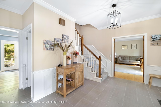 2038 Woodfield Rd, Okemos, MI 48864 - foyer with stairs, crown molding, a chandelier, a wainscoted wall, and a decorative wall