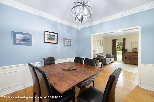 2038 Woodfield Rd, Okemos, MI 48864 - dining room featuring a chandelier, light wood-style flooring, wainscoting, and ornamental molding