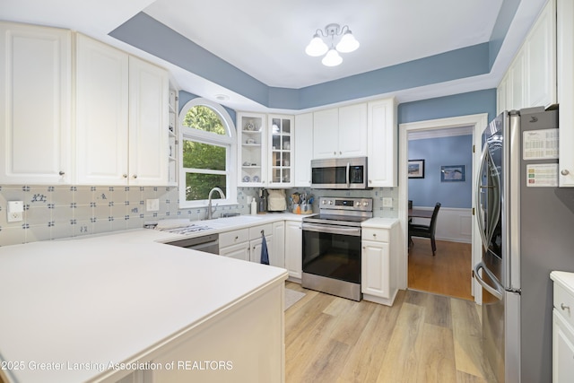 2038 Woodfield Rd, Okemos, MI 48864 - kitchen with stainless steel appliances, a sink, light wood finished floors, and white cabinetry