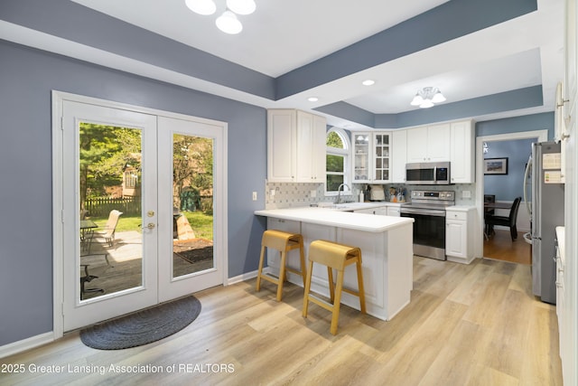 2038 Woodfield Rd, Okemos, MI 48864 - kitchen with stainless steel appliances, a peninsula, a chandelier, french doors, and recessed lighting