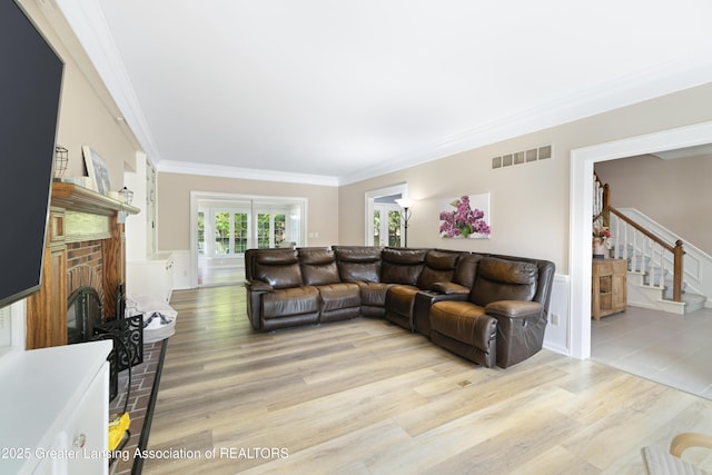 2038 Woodfield Rd, Okemos, MI 48864 - living area featuring stairs, a brick fireplace, light wood-type flooring, and ornamental molding