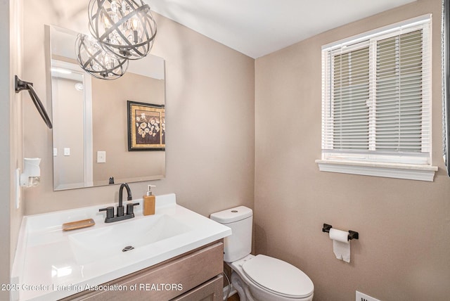 1626 Pepper Tree Ln Unit 13, Lansing, MI 48912 - half bathroom with toilet, vanity, and a chandelier