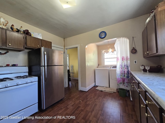 1045 N Larch St, Lansing, MI 48906 - kitchen featuring white gas range oven, freestanding refrigerator, washer and clothes dryer, arched walkways, and dark wood finished floors