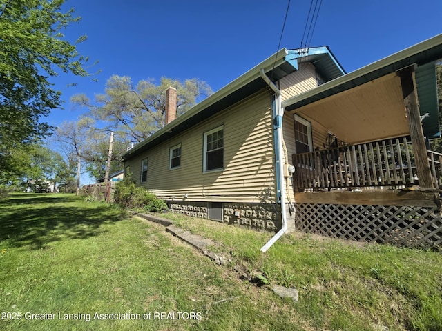 1045 N Larch St, Lansing, MI 48906 - view of side of property featuring a chimney, crawl space, and a yard