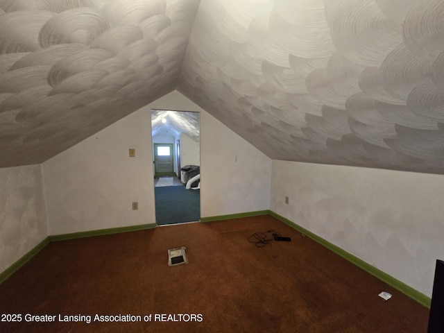 1045 N Larch St, Lansing, MI 48906 - additional living space with vaulted ceiling, carpet, and baseboards