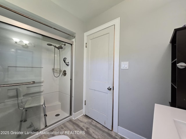 1045 N Larch St, Lansing, MI 48906 - full bath with wood finished floors, a stall shower, and baseboards