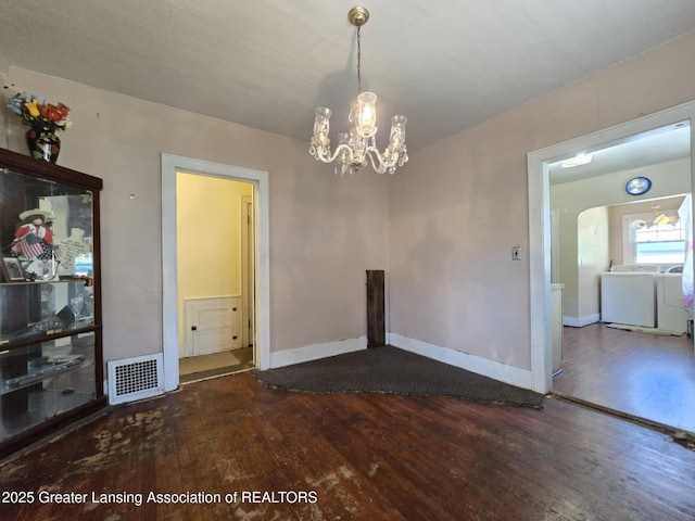 1045 N Larch St, Lansing, MI 48906 - unfurnished dining area with separate washer and dryer, hardwood / wood-style floors, a chandelier, and baseboards