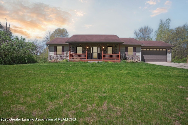 ranch-style home featuring a porch, a garage, a front lawn, and concrete driveway