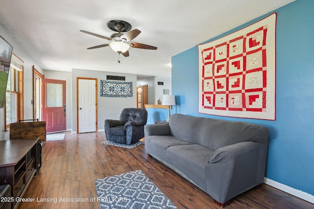 living area featuring a ceiling fan, dark wood finished floors, and baseboards