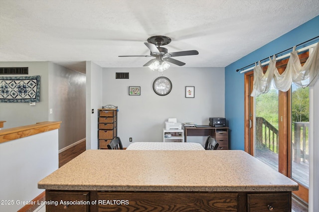 office with a ceiling fan, baseboards, a textured ceiling, and dark wood finished floors