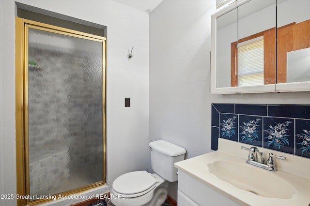 bathroom with a shower stall, toilet, and vanity
