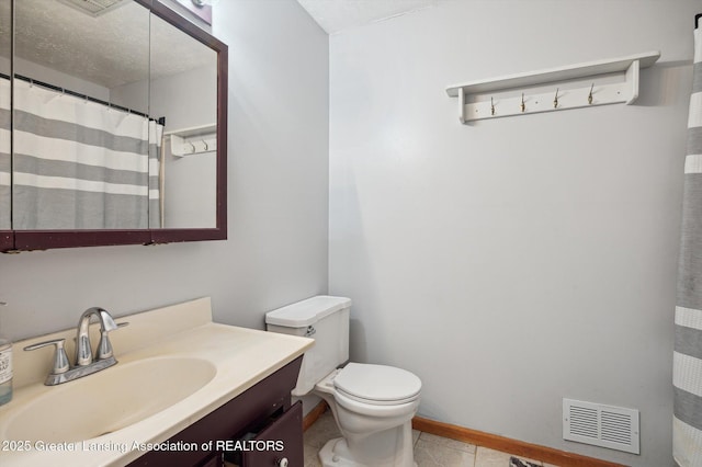 bathroom with vanity, tile patterned flooring, toilet, curtained shower, and a textured ceiling
