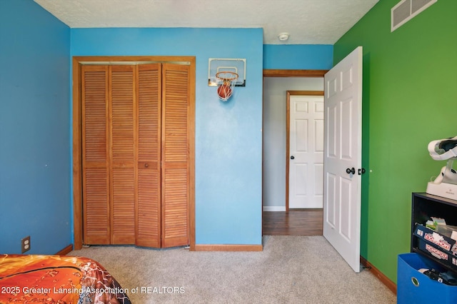 bedroom with carpet, baseboards, and a closet