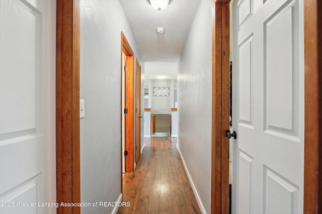 hallway with wood-type flooring and baseboards