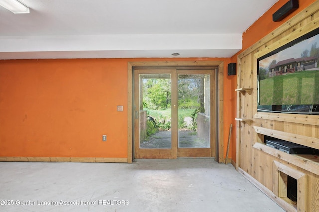 unfurnished living room featuring unfinished concrete flooring and baseboards
