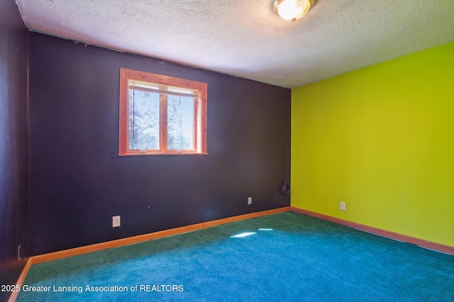 unfurnished room featuring a textured ceiling, carpet, and baseboards