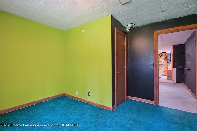 unfurnished room featuring carpet flooring, baseboards, and a textured ceiling