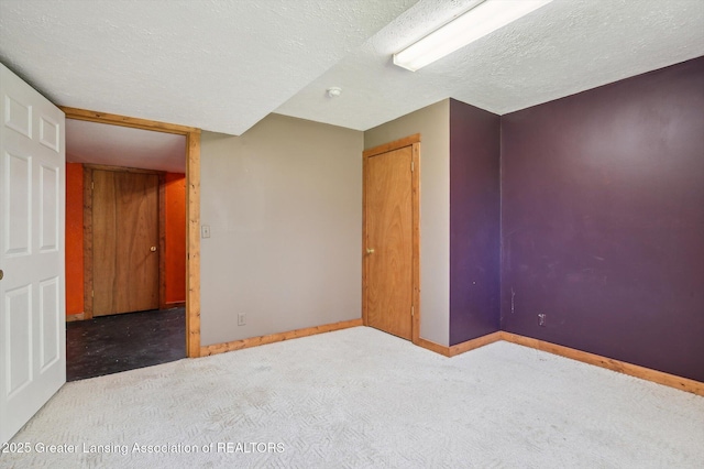 carpeted empty room with baseboards and a textured ceiling