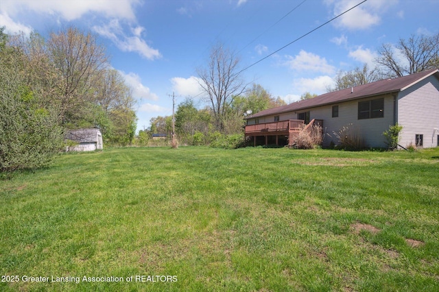 view of green lawn featuring a wooden deck