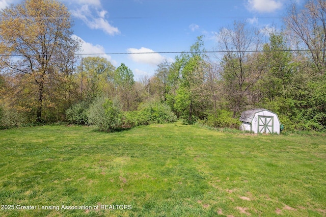view of grassy yard featuring a storage shed and an outdoor structure