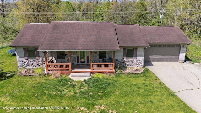 view of front of home featuring stone siding, driveway, an attached garage, and a front lawn