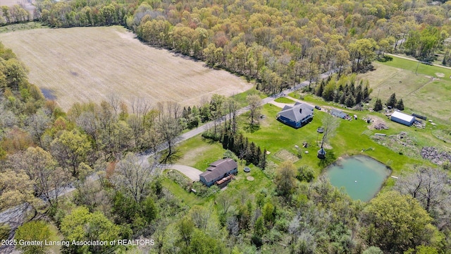 view of property location with a large body of water, rural landscape, and a forest