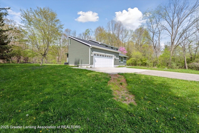 263 E Sherwood Rd, Williamston, MI 48895 - view of side of home featuring driveway, a yard, and a garage