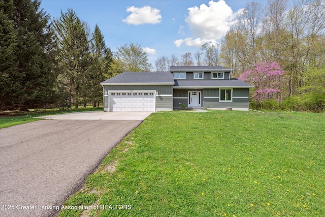 263 E Sherwood Rd, Williamston, MI 48895 - traditional home with asphalt driveway, an attached garage, a front yard, and a shingled roof