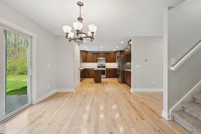 263 E Sherwood Rd, Williamston, MI 48895 - kitchen featuring stainless steel appliances, light countertops, open floor plan, a chandelier, and baseboards