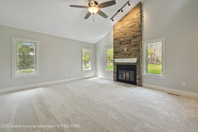 263 E Sherwood Rd, Williamston, MI 48895 - unfurnished living room featuring track lighting, baseboards, high vaulted ceiling, a fireplace, and ceiling fan