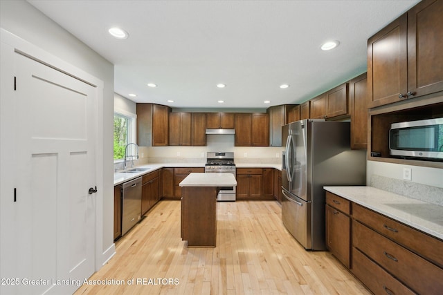 263 E Sherwood Rd, Williamston, MI 48895 - kitchen with appliances with stainless steel finishes, a sink, a center island, light countertops, and light wood-type flooring