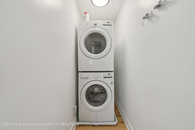 263 E Sherwood Rd, Williamston, MI 48895 - clothes washing area with stacked washer / drying machine, light wood-type flooring, and baseboards
