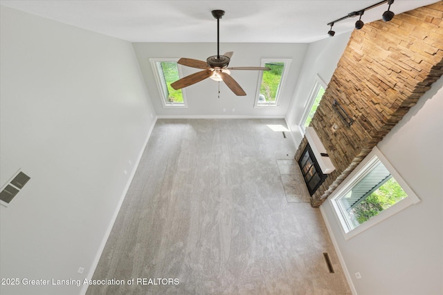 263 E Sherwood Rd, Williamston, MI 48895 - unfurnished living room with carpet flooring, baseboards, rail lighting, and ceiling fan