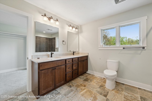 263 E Sherwood Rd, Williamston, MI 48895 - full bath featuring baseboards, double vanity, toilet, and stone finish flooring