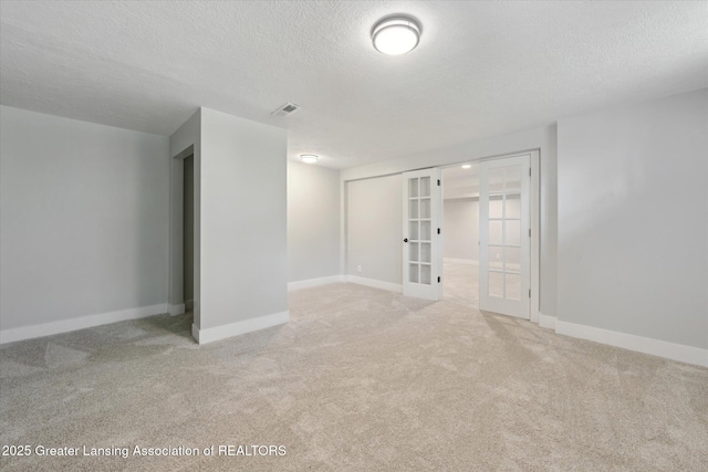263 E Sherwood Rd, Williamston, MI 48895 - spare room with french doors, a textured ceiling, light carpet, and baseboards