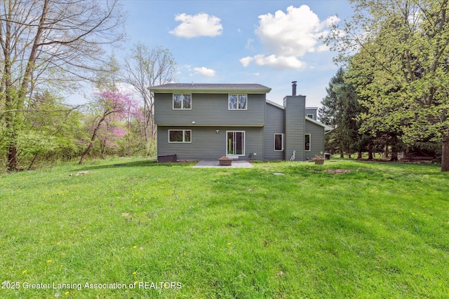 263 E Sherwood Rd, Williamston, MI 48895 - rear view of property with a patio, a chimney, and a yard