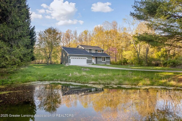 263 E Sherwood Rd, Williamston, MI 48895 - rear view of property with a garage, a yard, and a water view