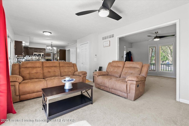 living area featuring ceiling fan, light colored carpet, a chandelier, a textured ceiling, and baseboards