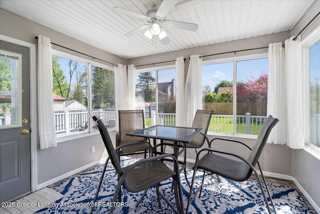 sunroom with baseboards, healthy amount of natural light, wood finished floors, and wood ceiling