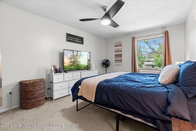 bedroom featuring light carpet, a textured ceiling, and ceiling fan